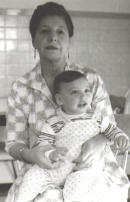 Une femme assise, avec un bébé sur les genoux.
