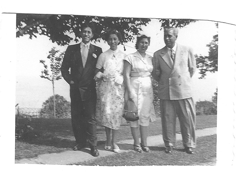 Deux couples bien habillés se tiennent ensemble et sourient pour la caméra.