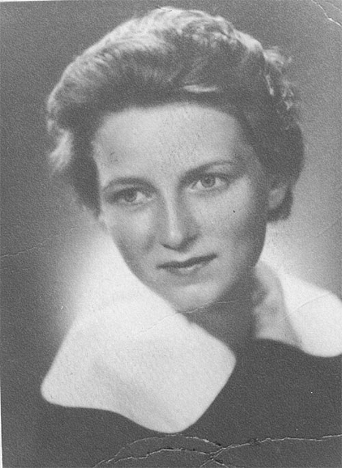 Portrait facial d’une jeune femme aux cheveux courts, elle porte un haut avec un gros col blanc.