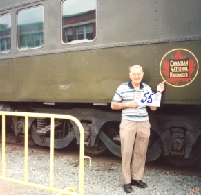 Siegfried, homme âgé, debout devant un wagon de train. 