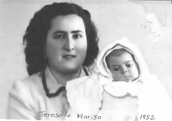 Jeune mère et petit bébé, tous deux vêtus de blanc.