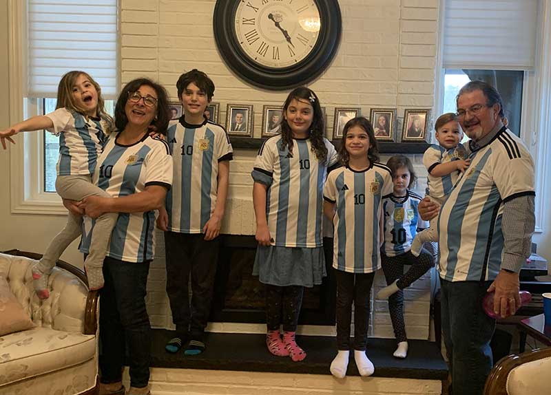 Plusieurs membres d’une famille, d’âges différents, debout et qui portent des gilets de sport identiques.