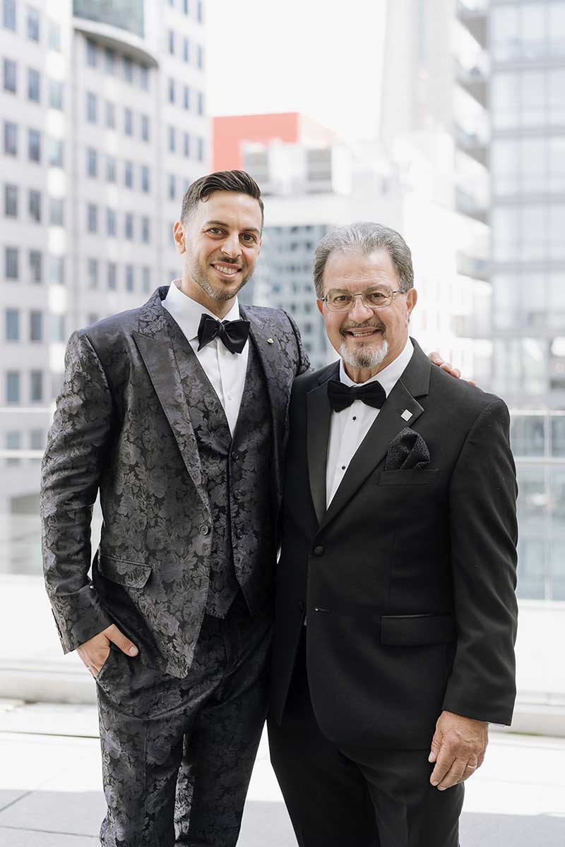 Un jeune homme très bien habillé se tient à côté de son père le jour de son mariage.