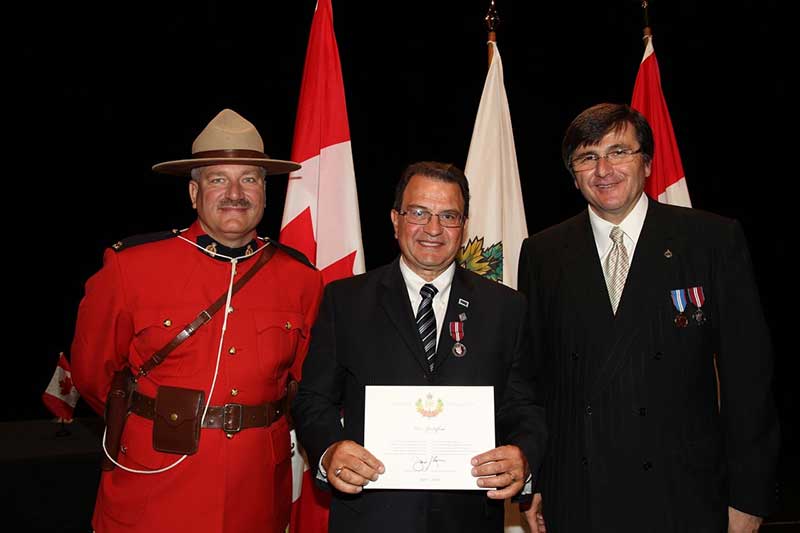 Un homme avec un certificat entre deux fonctionnaires.