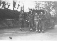 Groupe de soldats debout devant la jeep de l’armée.
