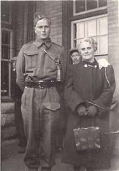 Un jeune homme en uniforme, à côté d’une femme tenant son sac.