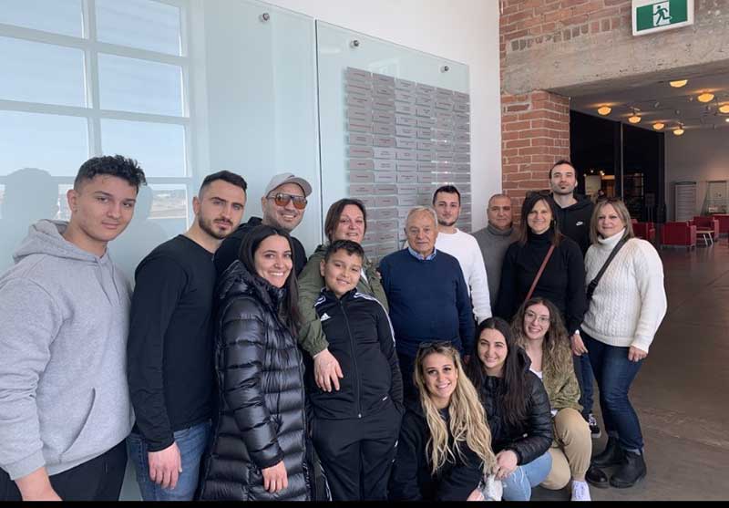 Photo de beaucoup de membres de la famille, debout devant un mur avec des plaques.