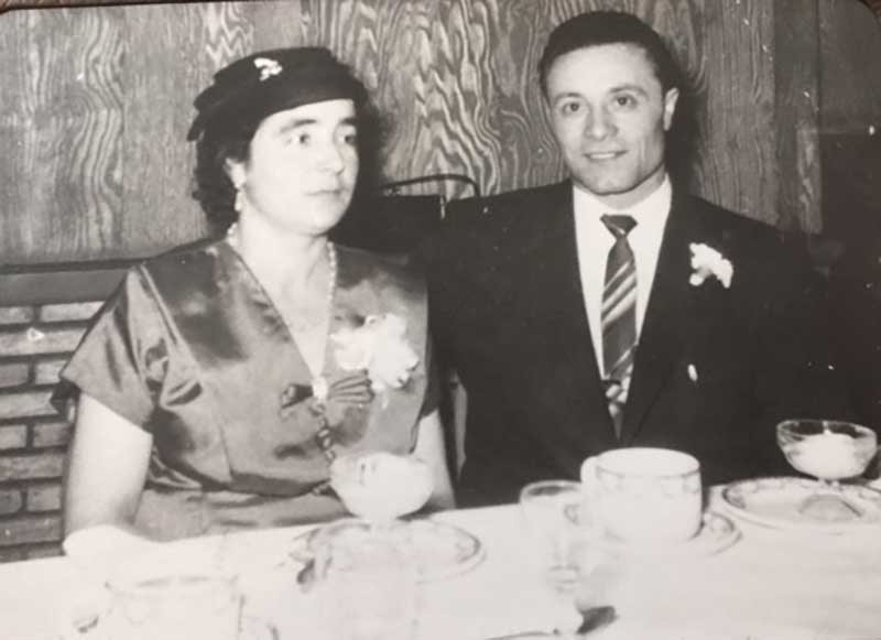 Un couple bien habillé assis à table.