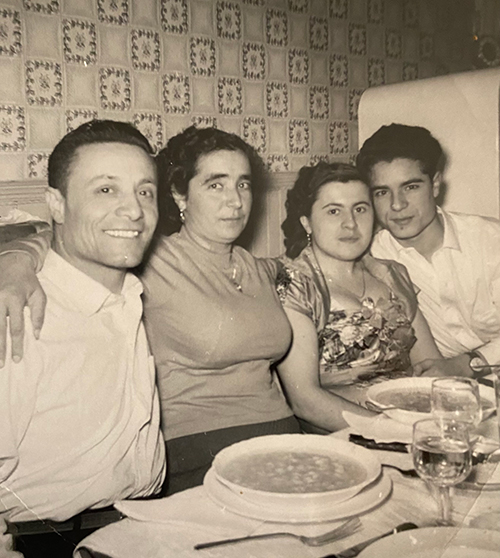 Deux couples assis à une table à manger posent pour la caméra.