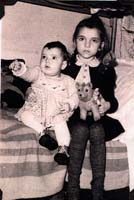 Petite fille et un bébé assis au bord d’un lit.