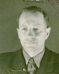 Gros plan du visage de Janis, jeune homme, portant un costume foncé et une cravate.