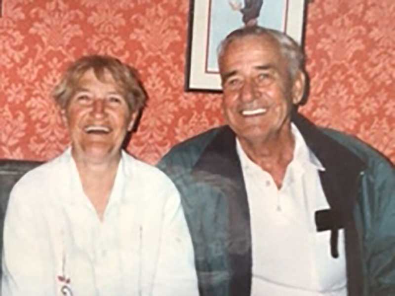 Un couple est assis et souriant pour une photo.