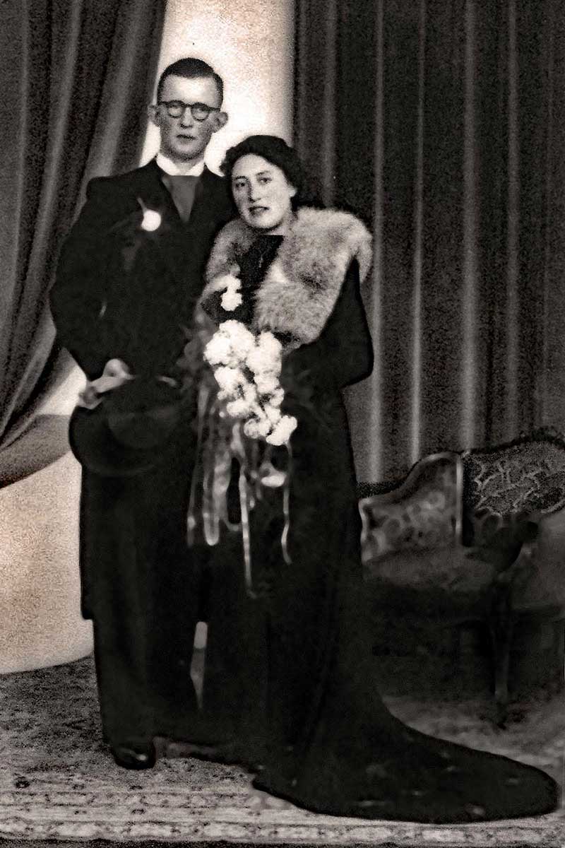 Un homme et une femme se tiennent dans de beaux vêtements le jour de leur mariage.