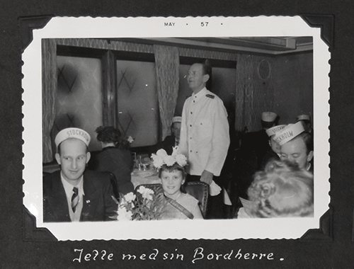 Petite belle fille assise avec un bel homme portant une casquette, et serveur debout derrière eux.