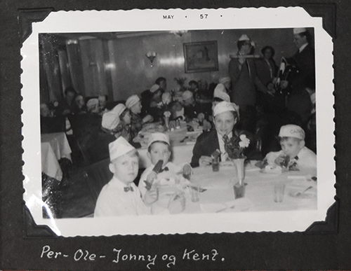 Photo en noir et blanc de trois enfants et d’une belle dame assis avec eux et tenant la crème glacée dans les mains.