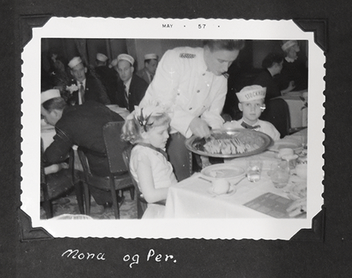 Deux enfants sont assis et le serveur leur sert à manger.