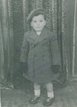 Petit garçon Clifford en manteau, gants et tam.