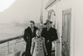 Photographie en noir et blanc d’un homme, d’une femme et d’un garçon à bord d’un navire.
